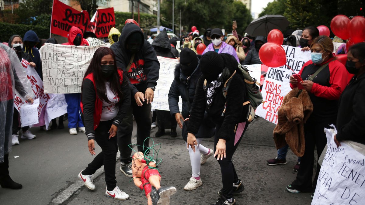 Trabajadoras sexuales rompen un muñeco de manera simbólica durante una protesta en contra de la extorsión policial hoy, en La Paz (Bolivia).