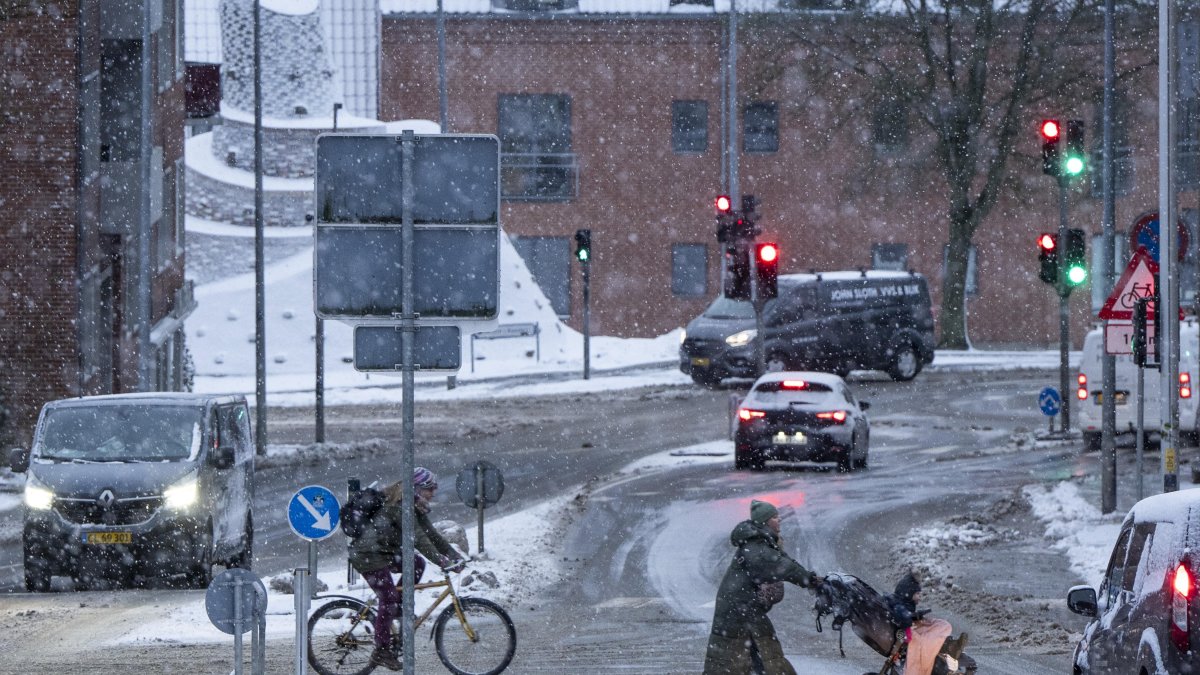 Varias personas cruzan una calle durante las nevadas en Randers, en la península de Jutlandia, Dinamarca, el 17 de enero de 2024.