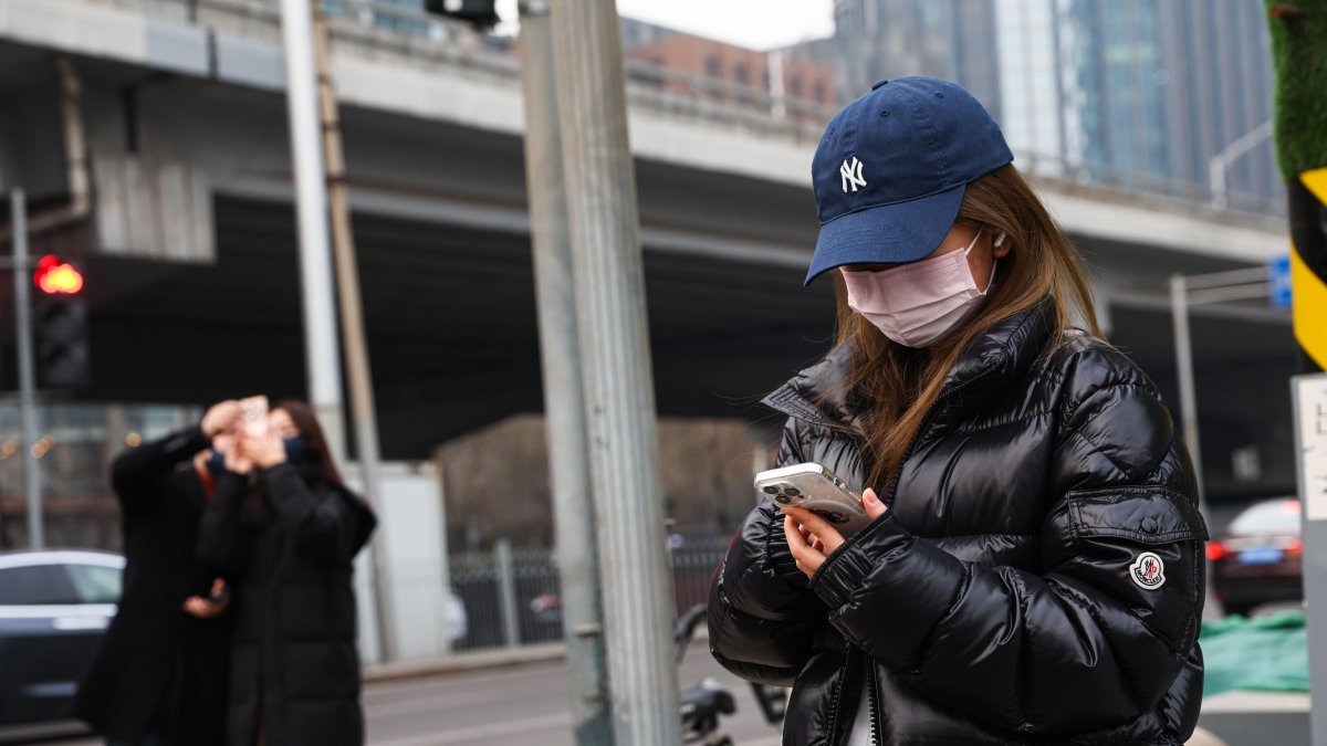 Una calle de Pekín, donde varias personas aparecen en diferentes ocupaciones.