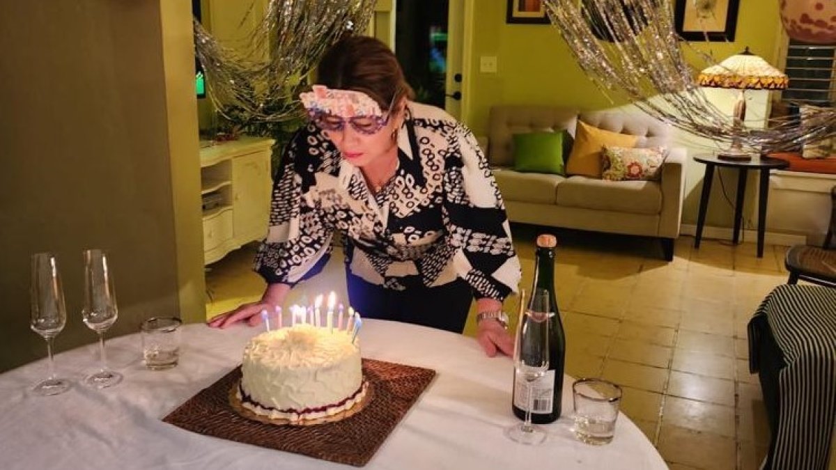 Gloria Acosta soplando las velas de su cumpleaños.