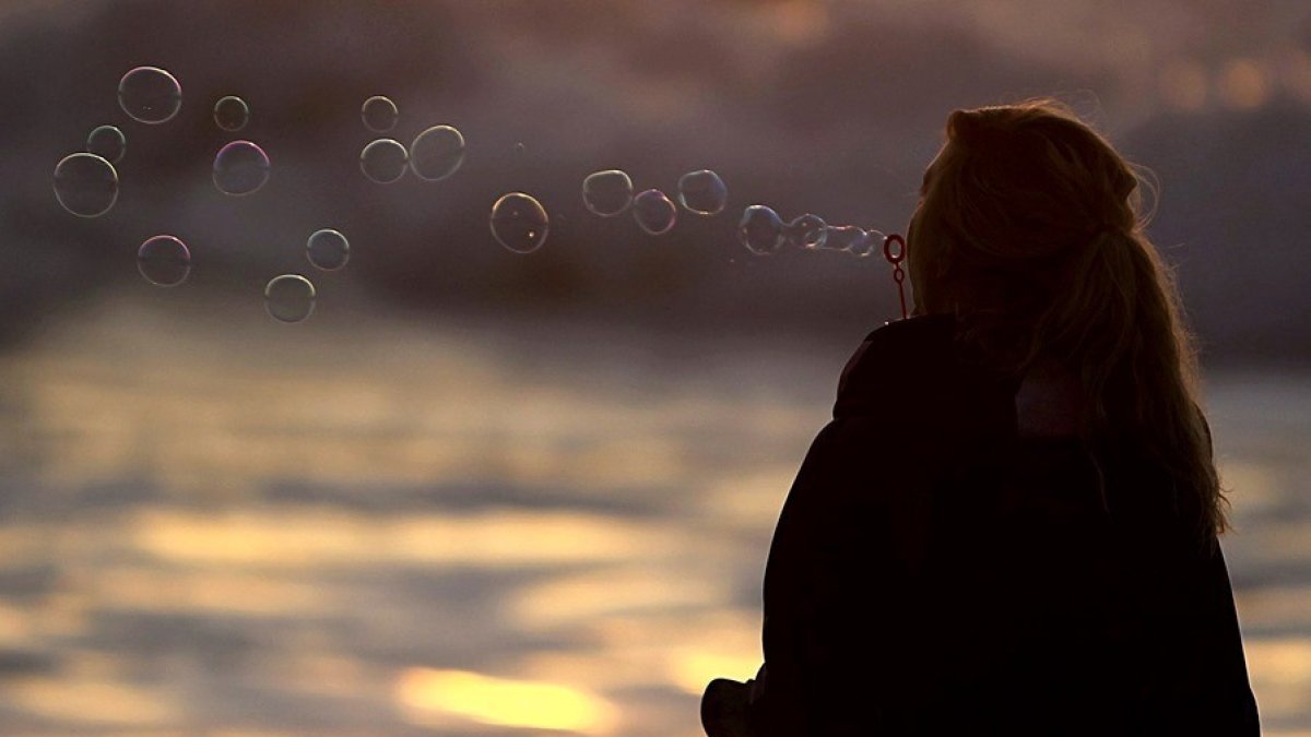 Referencial. una joven en la playa durante el atardecer.