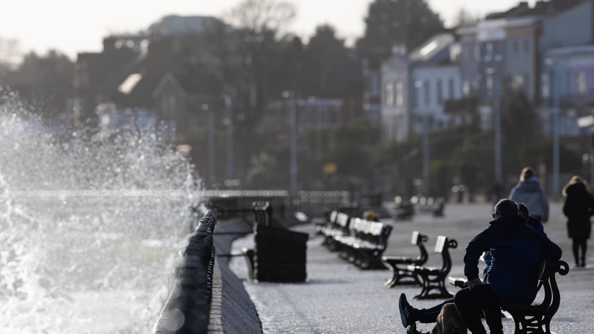 Un grupo de personas observa cómo las olas rompen sobre el malecón en New Brighton, Gran Bretaña, este 22 de enero de 2024.