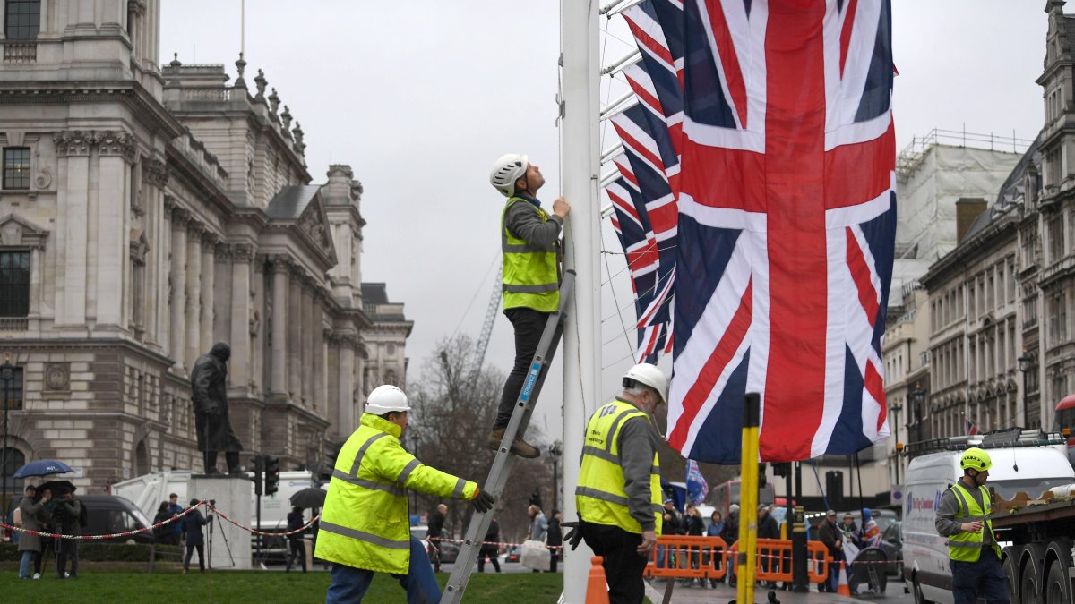 Labor.- Un grupo de trabajadores ponen las banderas de Reino Unido.