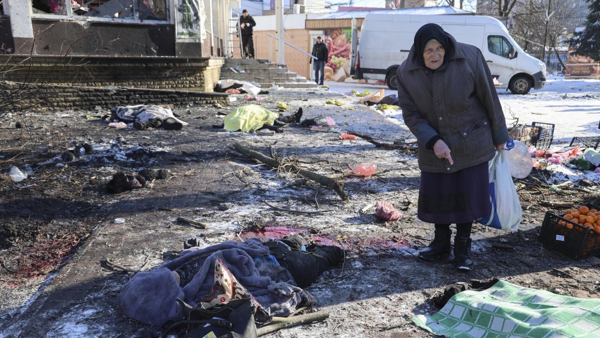 Una mujer camina entre los cuerpos de las víctimas del bombardeo del mercado de alimentos de Donetsk, Ucrania, este 21 de Enero.