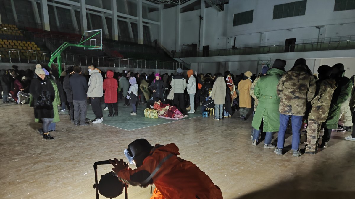 Un miembro de la empresa local de suministro de energía instala equipos de iluminación en un refugio temporal en el condado de Akqi, prefectura autónoma kirgiz de Kizilsu, el 23 de enero de 2024.