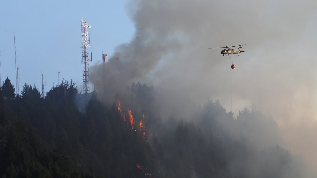 Un helicóptero combate este miércoles 24 de enero de 2024 un incendio forestal en el cerro El Cable, en Bogotá (Colombia).