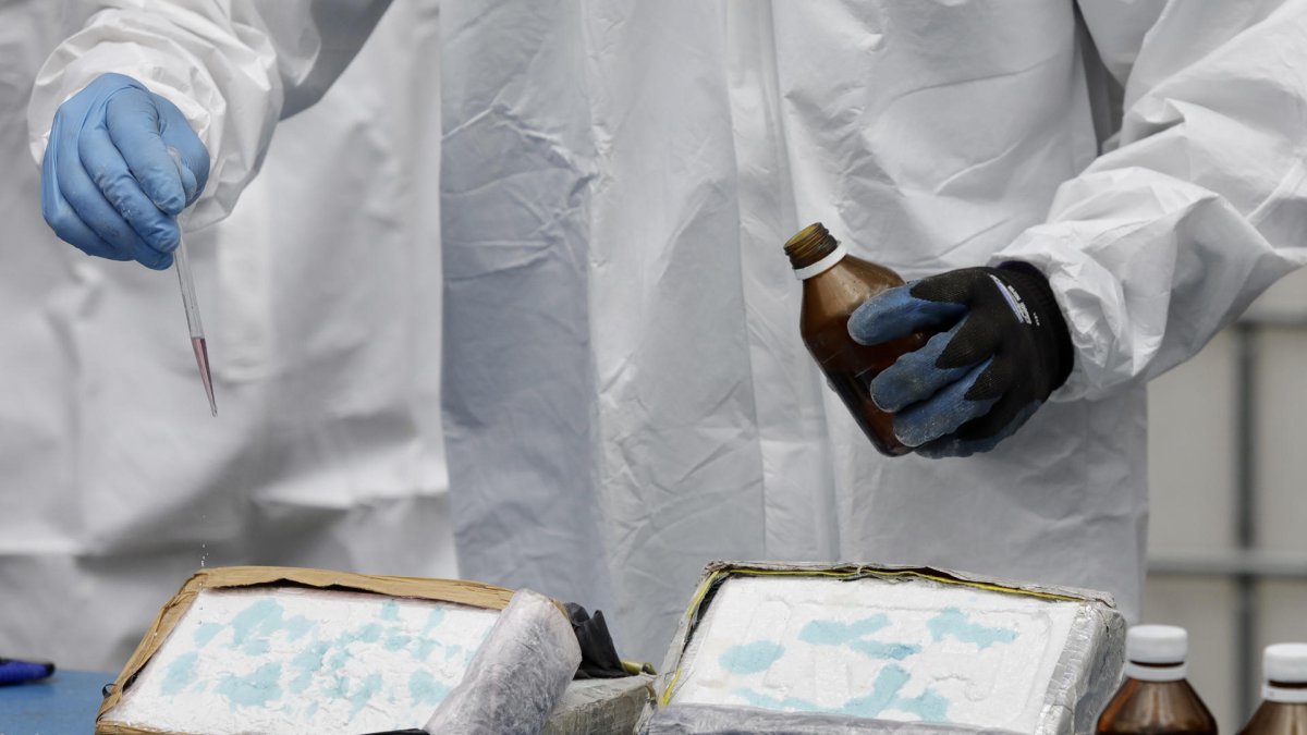 Referencial. Un operario rocía reactivos químicos sobre dos bloques de cocaína para corroborar que se trata de droga.