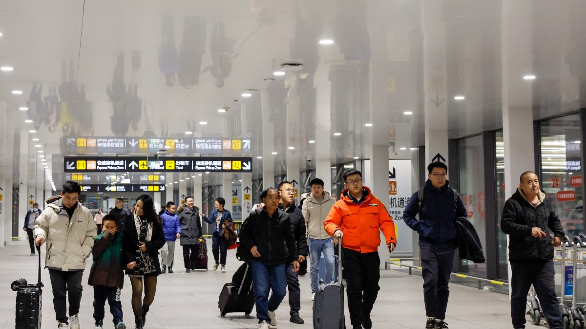 Beijing (China), 25/01/2024.- Los viajeros llegan al Aeropuerto Internacional Daxing de Beijing, China, 26 de enero de 2024.