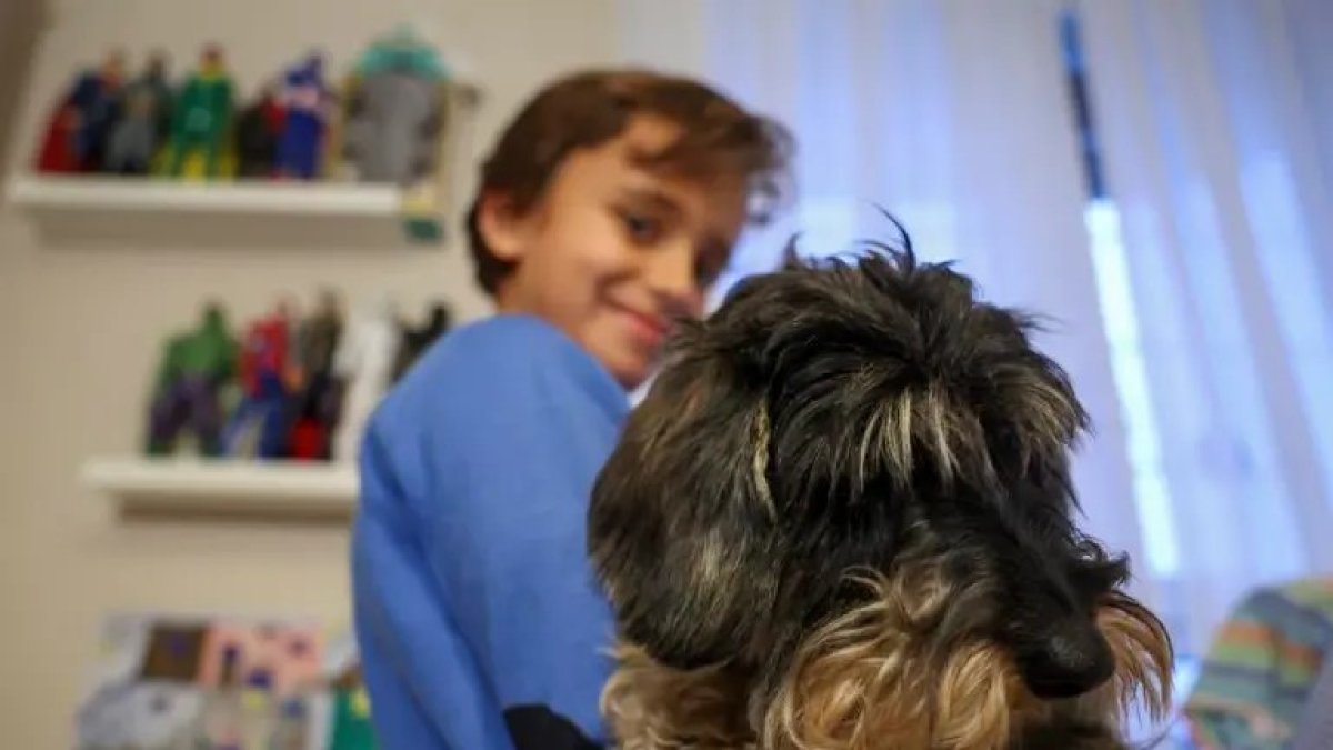 El niño Javier Bañuelos, trasplantado, posa junto a su mascota de terapia.