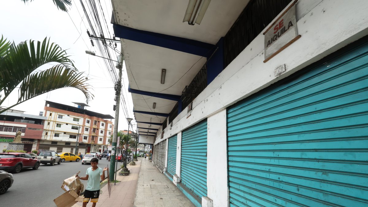 Comercio. Un ciudadano camina por la acera de una calle principal de Quevedo, junto a una serie de locales que permanecen cerrados, por alquilar o vender.