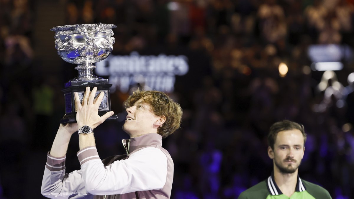 El italiano Jannik Sinner (i) levanta el trofeo Norman Brookes tras vencer en la final del Open de Australia al ruso Daniil Medvedev (d) en Melbourne, Australia.