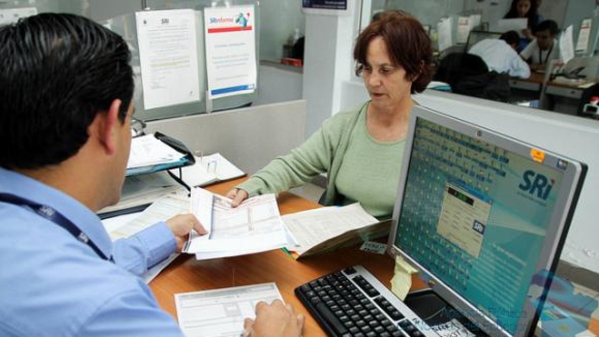 FUNCIONARIO DEL SRI ATIENDE A UNA MUJER CONTRIBUYENTE.