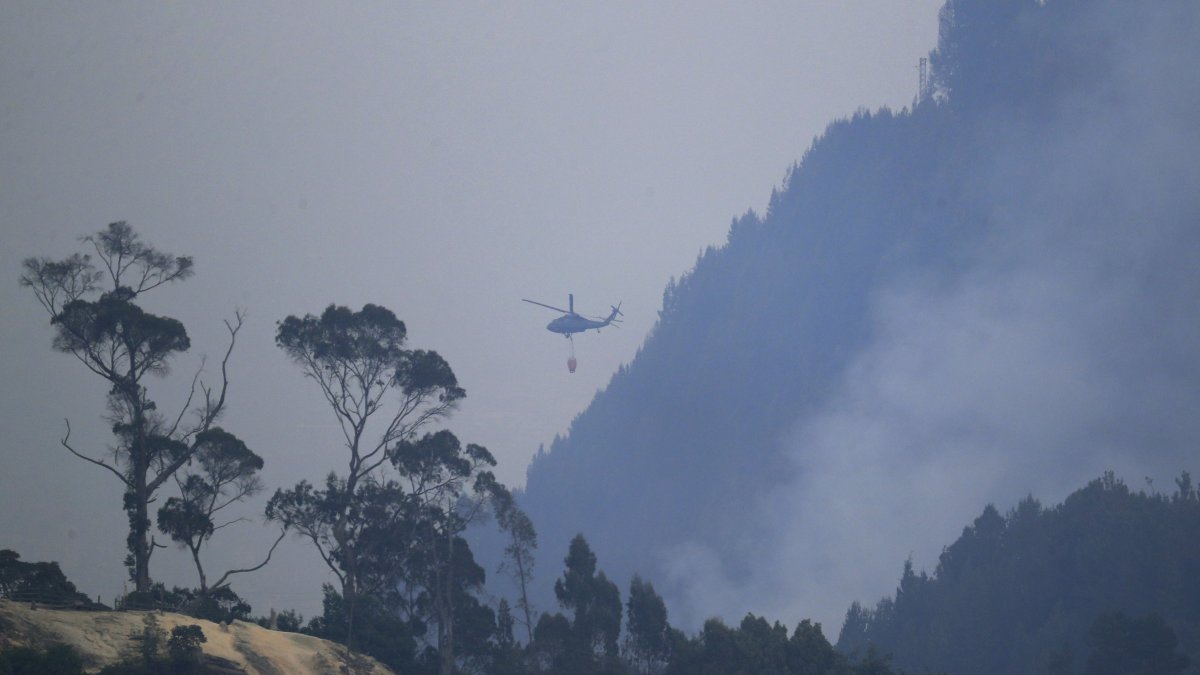 Un helicóptero combate este lunes 29 de enero de 2024 un incendio forestal en el cerro El Cable, en Bogotá (Colombia).