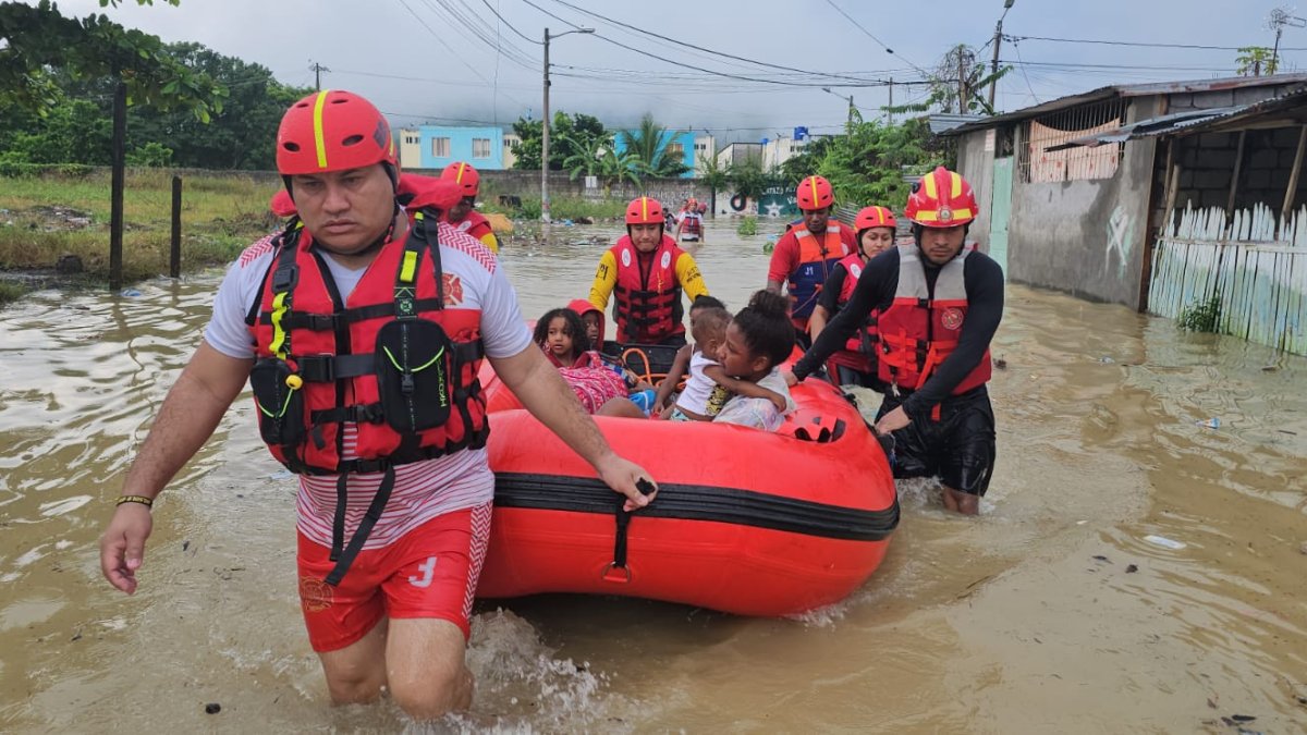 Los bomberos rescatan en una boya a un grupo familiar que estaba atrapado en su casa por la inundación.