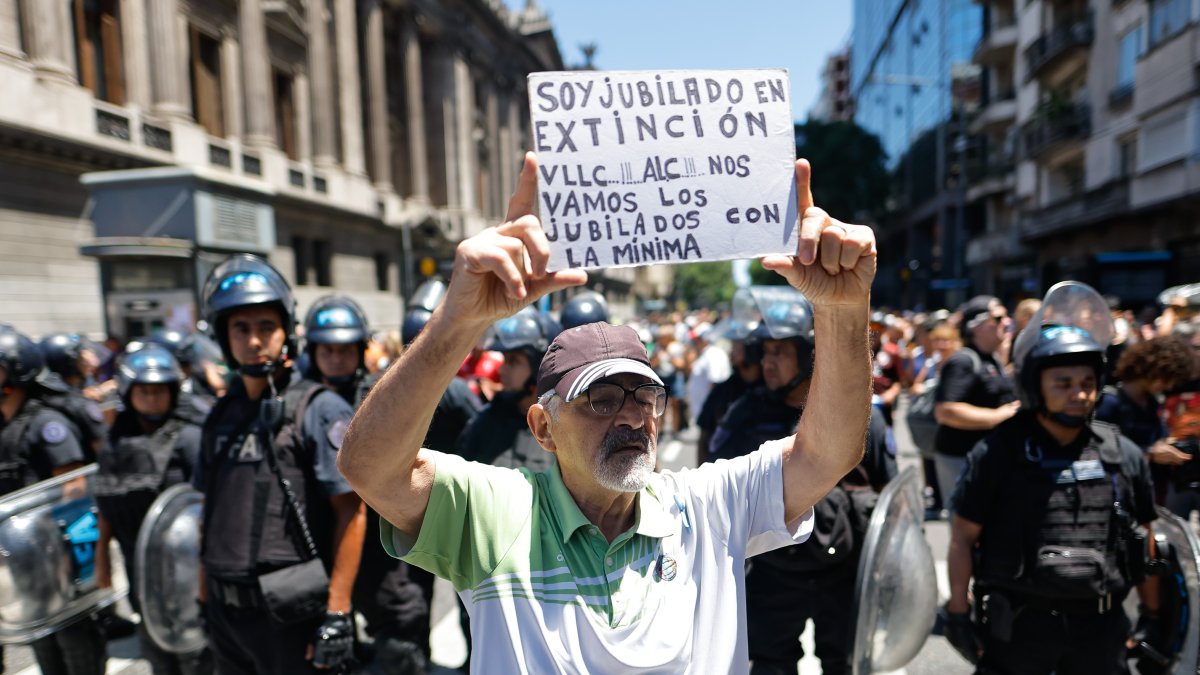 Un hombre sostiene un cartel durante una protesta convocada por la Confederación General del Trabajo en Buenos Aires (Argentina).