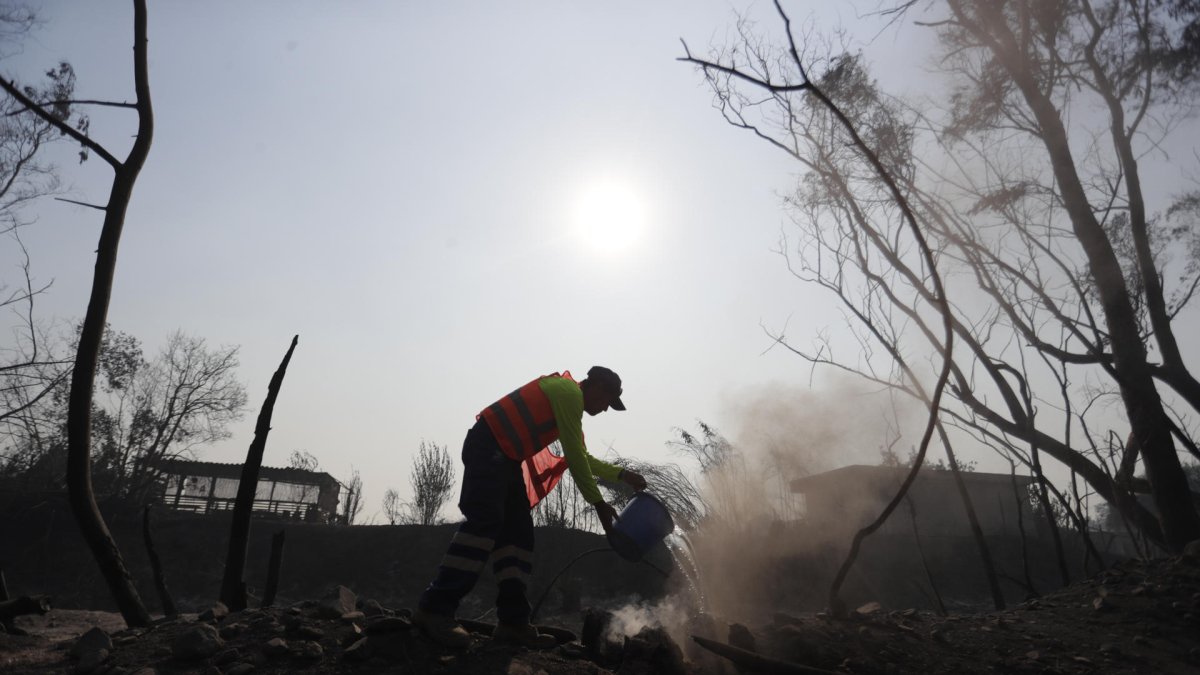 Bomberos y voluntarios tratan de extinguir los focos de un incendio en la zona de Patagual, en Viña del Mar (Chile).