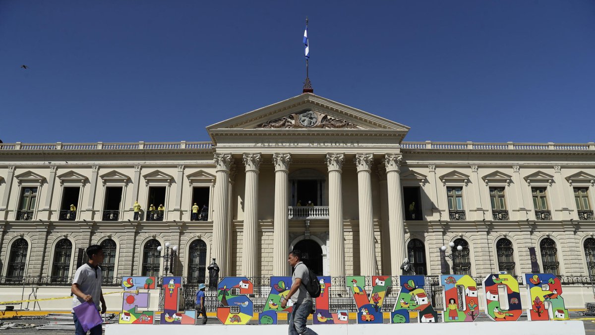 Personas caminan frente al Palacio Nacional, en el centro de San Salvador.