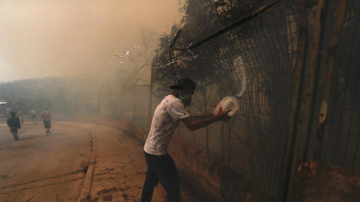 Personas combaten el fuego en la zona de Las Palmas, durante los incendios forestales que afectan a Viña del Mar, este sábado 3 de febrero.