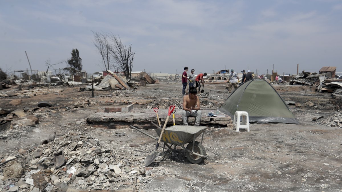 Personas del campamento irregular “Pompeya” recogen escombros, tras los incendios del día viernes 2 de febrero de 2024, en la zona de Viña del Mar, Región de Valparaiso (Chile).