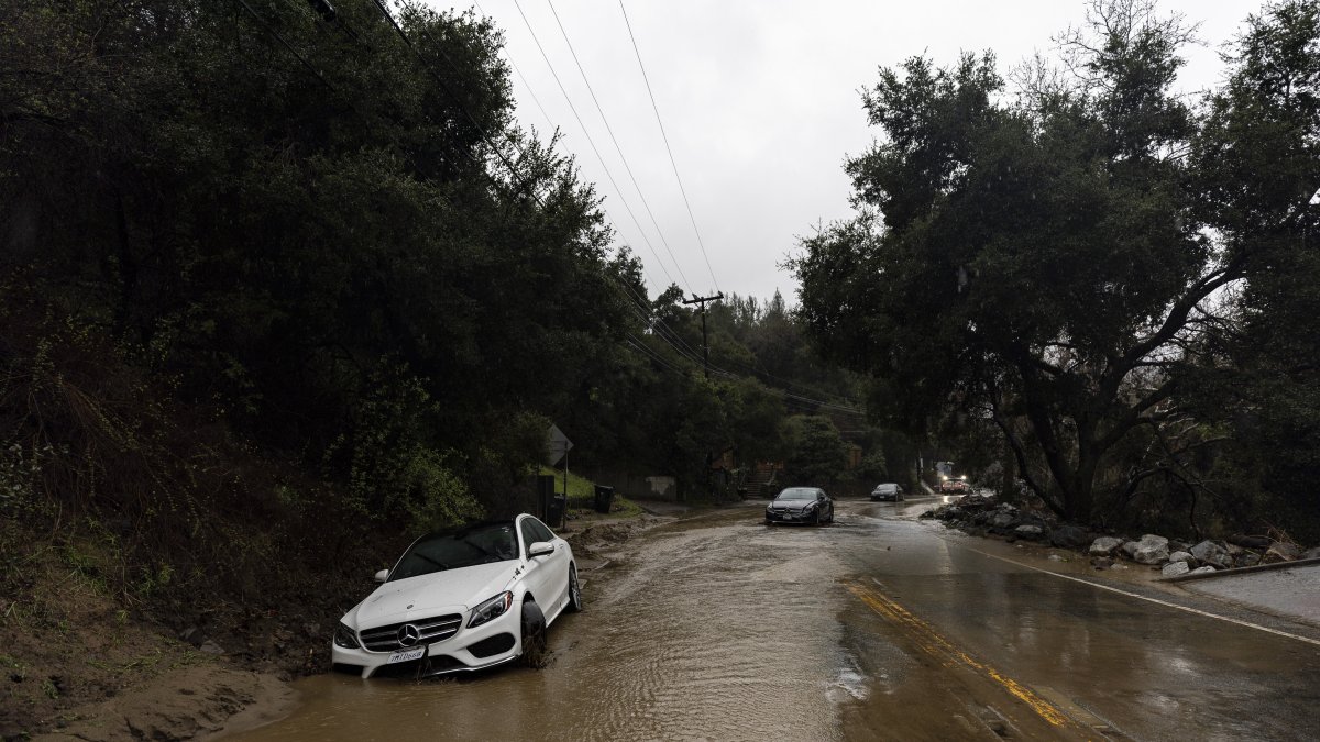 Los vehículos afectados por un deslizamiento de tierra son abandonados en la carretera mientras una tormenta azota el sur de California provocando lluvias torrenciales y fuertes vientos.