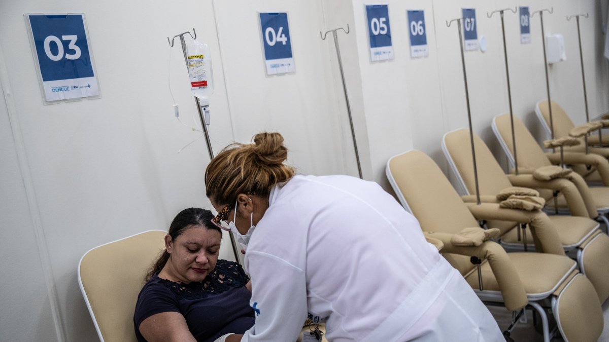 Una trabajadora de la salud revisa a una paciente sospechosa de dengue hoy, en el Centro de Atención de Dengue de la Policlínica Rodolpho Rocco, en el barrio Del Castilho, en Río de Janeiro (Brasil).