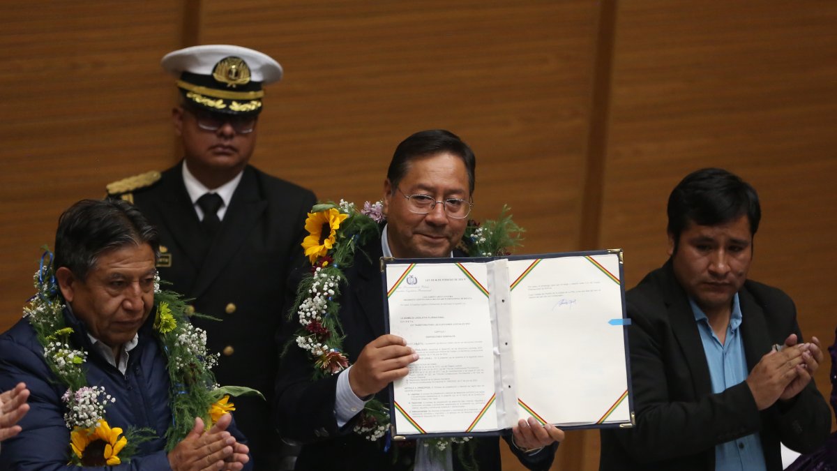 El presidente de Bolivia, Luis Arce (c), sostiene la ley para elecciones judiciales tras su promulgación este 6 de febrero de 2024, en la 'Casa Grande', en La Paz (Bolivia).