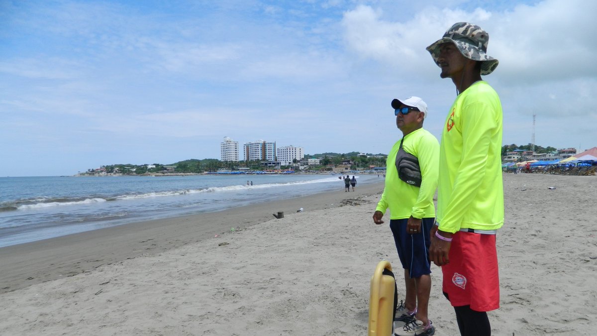 Dos salvavidas vigilan a los escasos bañistas en un sector de la playa de General Villamil.