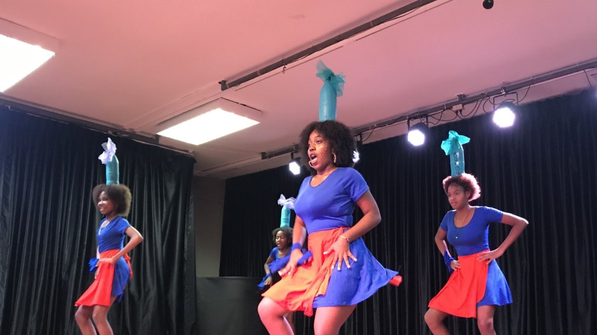 El grupo Orisha baila al son de la bomba choteña, con la tradicional botella sobre la cabeza. Lo hace en el escenario en Guayaquil.