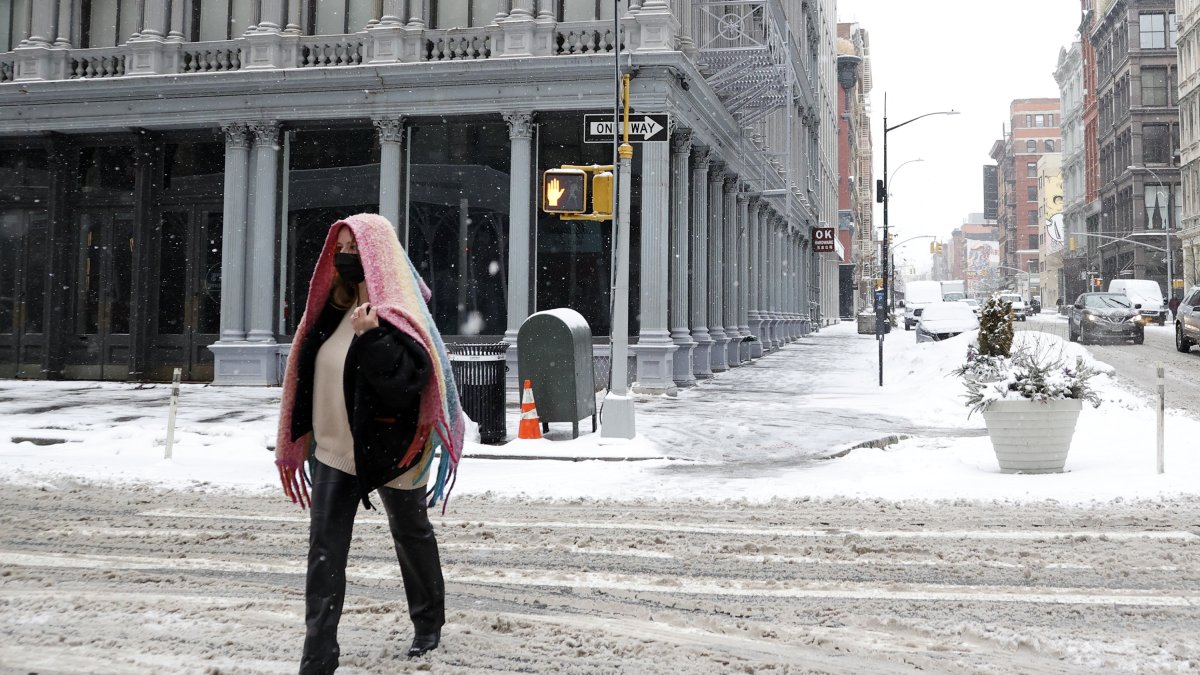 Nueva York. Una persona camina por una calle cubierta por la nieve.