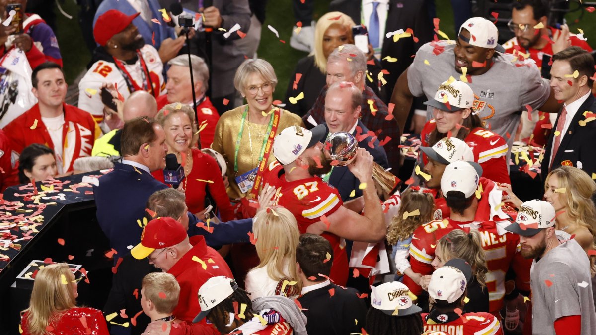 El jugador de los Kansas City Chiefs, Travis Kelce (c) levanta el trofeo de campeón tras la victoria de su equipo ante los San Fransisco 49ers durante la Super Bowl.