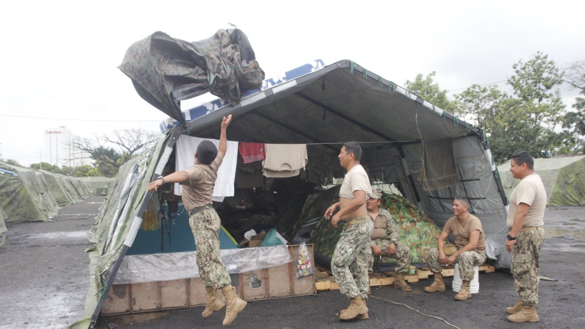 Personal de tropa coloca plásticos en las carpas del campamento para evitar mojarse con las constantes precipitaciones.