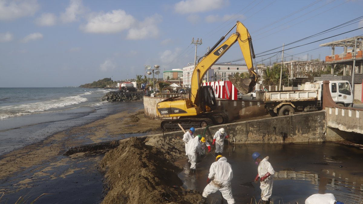 Unos trabajadores limpian un derrame de petróleo, el 12 de febrero del 2024, en la playa Rockly Bay, en la ciudad de Scarborough en la isla Tobago (Trinidad y Tobago).