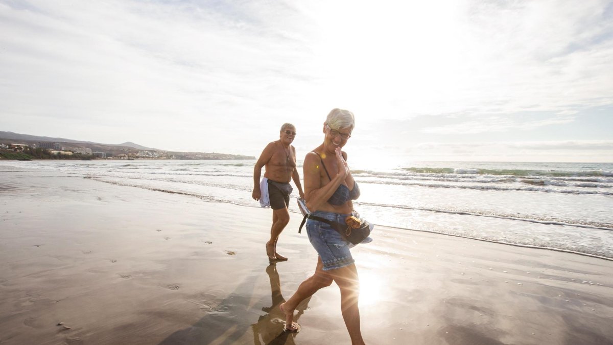 En la imagen de archivo, un hombre y una mujer pasean por la orilla de la Playa del Inglés (Gran Canaria, España).