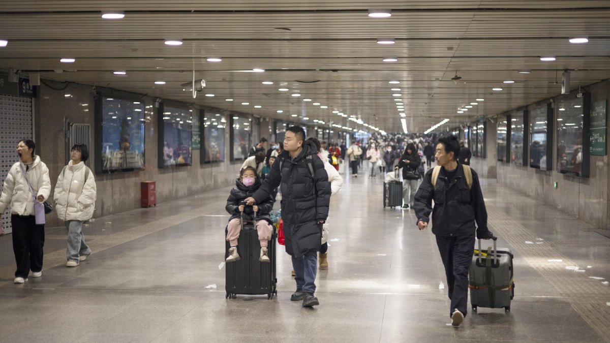 Pekín. Familias enteras esperan su tren en la estación de esta capital.