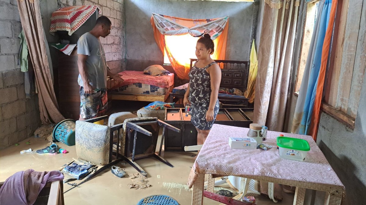 Una familia mira los destrozos causados en su vivienda por las lluvias y el desbordamiento de un río cercano en el cantón Muisne, Esmeraldas.