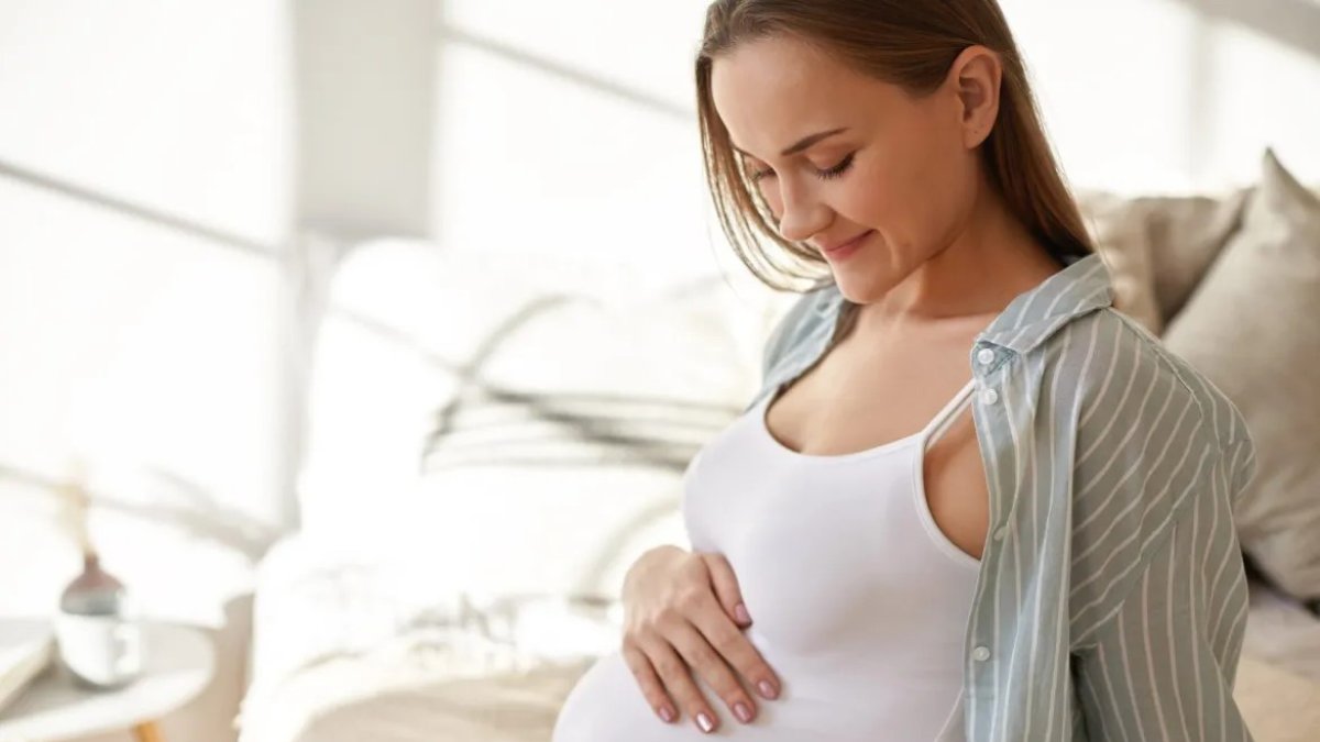 Embarazada observa su vientre con emoción