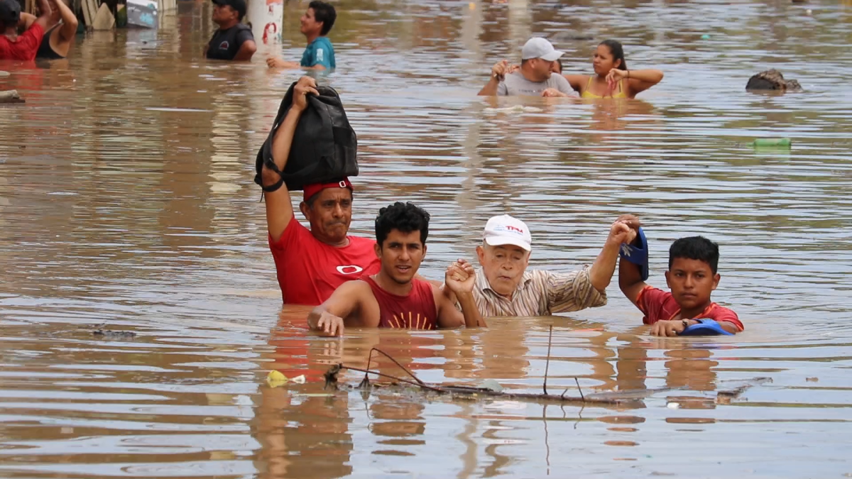 La imagen de un abuelo rescatado del agua por sus nietos evidencia la magnitud de la situación por las lluvias en Chone, Manabí.