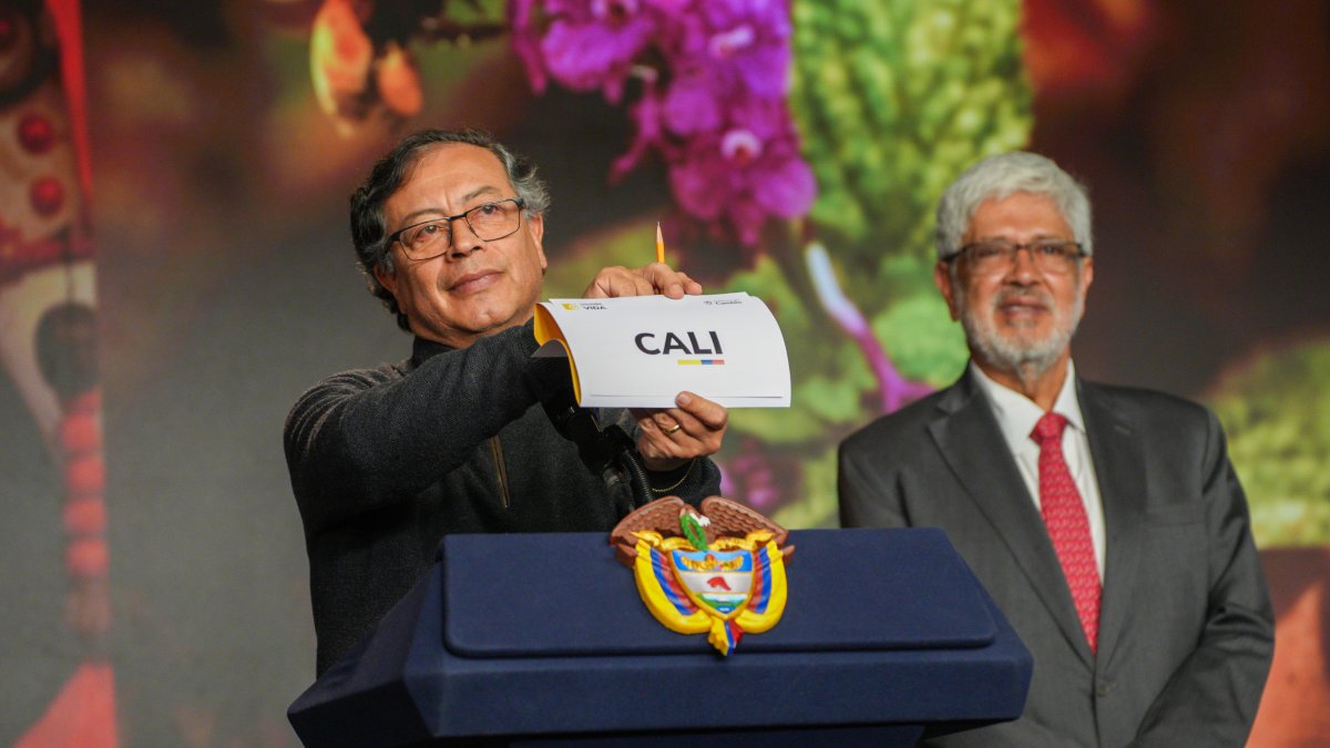 El mandatario Gustavo Petro sostiene un cartel con el nombre Cali, ciudad escogida par ser la sede de la Conferencia de la Organización de Naciones Unidas sobre Biodiversidad (COP16).