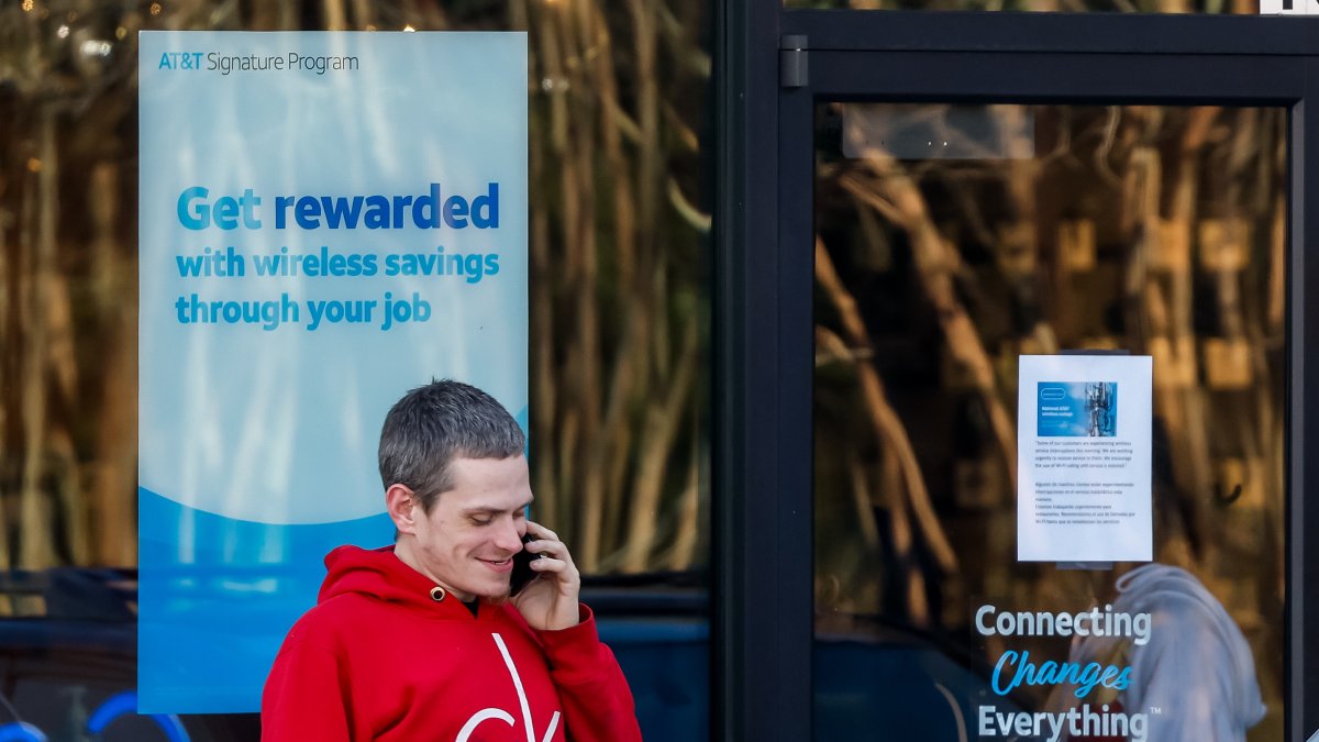 Una persona habla por su teléfono móvil afuera de una tienda minorista de AT&T en Tucker, Georgia, EE.UU.