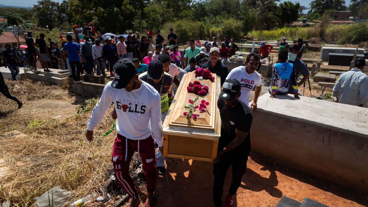 Familiares y simpatizantes participan en el entierro de una de las victimas mortales del derrumbe en la mina 'Bulla Loca' este jueves, en La Paragua (Venezuela).