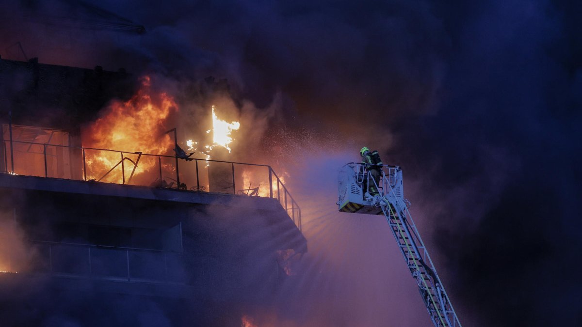 Bomberos trabajan en el incendio declarado sobre las cinco y media de esta tarde en un quinto piso de un edificio de viviendas de Valencia que ha afectado totalmente al inmueble y se ha propagado a otro anexo.