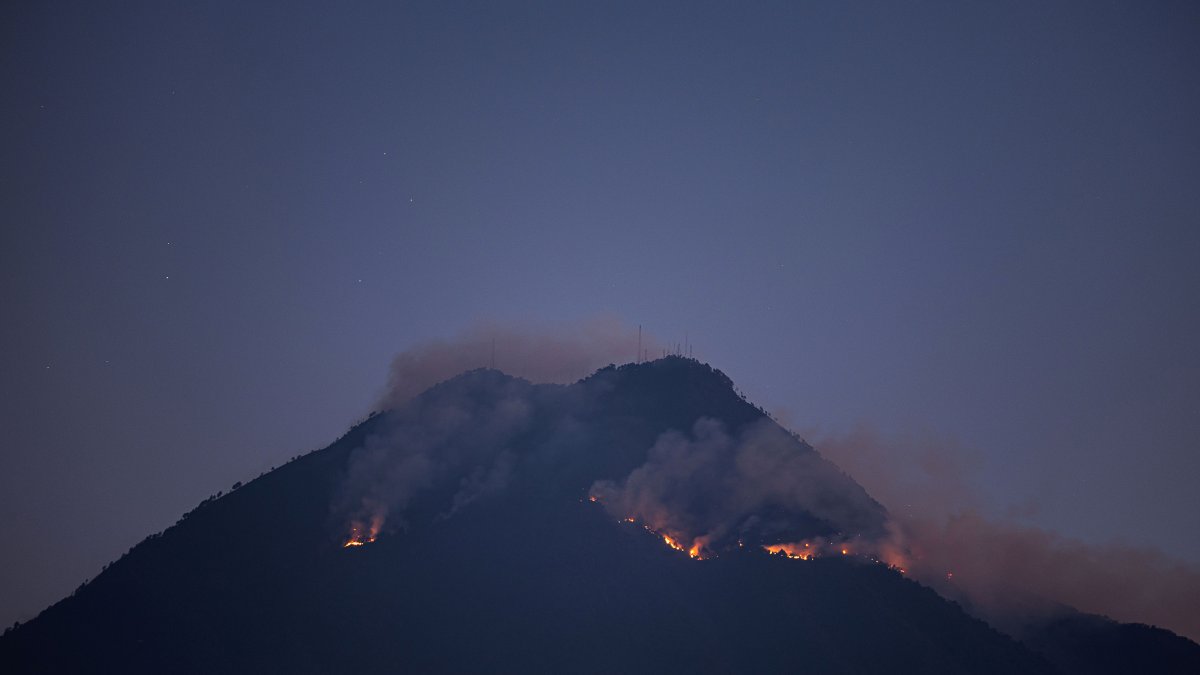 Un incendio en el volcán de Agua ayer jueves, desde la ciudad colonial de Antigua Guatemala (Guatemala).