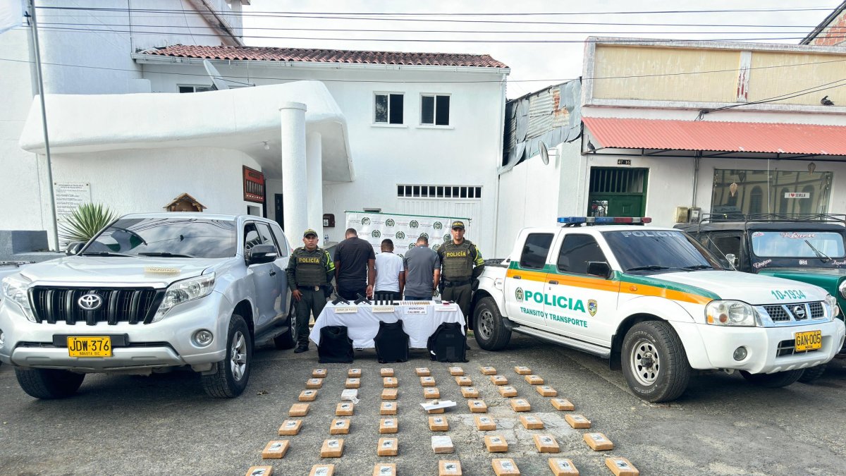 Las tres personas detenidas con la droga decomisada.