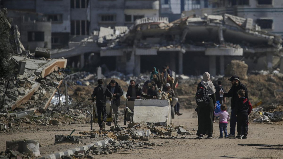 Palestinos caminan junto al campo de refugiados de Al Nusairat, en el sur de la Franja de Gaza.