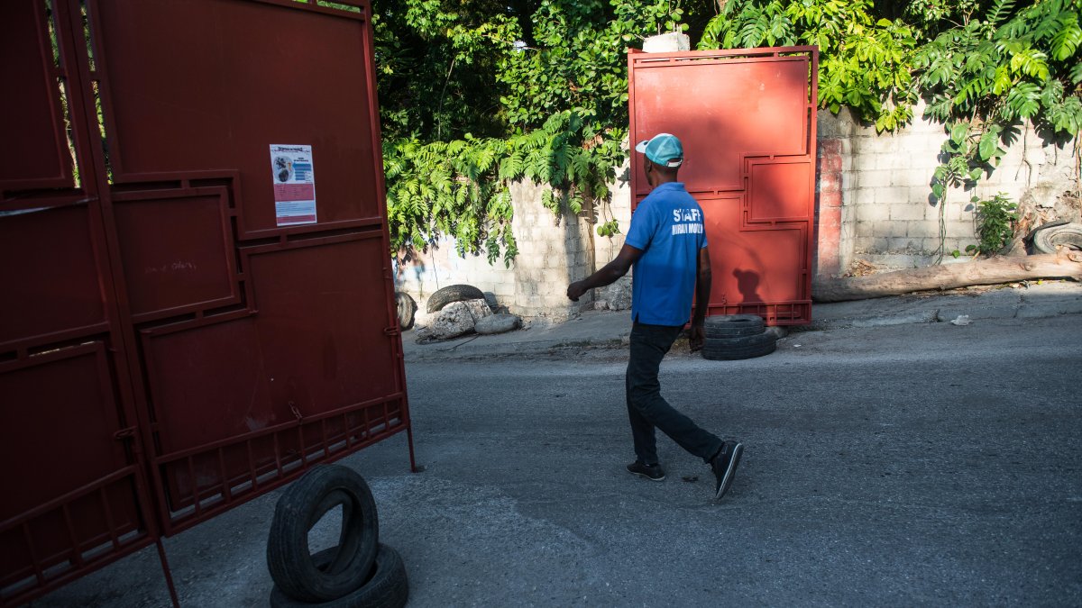 Un hombre cruza una barrera a la entrada de un barrio, este domingo en Puerto Príncipe (Haití).