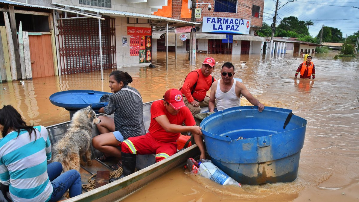 Fotografía de referencia de personas transportándose en lanchas después de que un río aumentara su caudal.