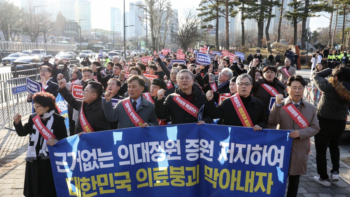Los médicos portan una pancarta mientras marchan hacia la oficina presidencial en el distrito de Yongsan, Seúl, Corea del Sur, el 25 de febrero de 2024.