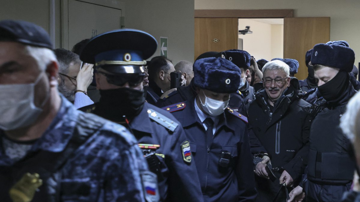 Moscú. Policías escoltan al activista Oleg Orlov, cofundador de Memorial.
