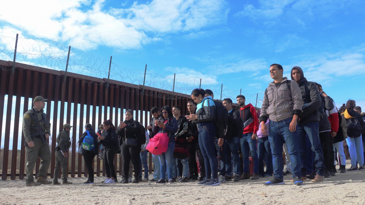 Algunos agentes de la Patrulla Fronteriza estadounidense con un grupo de migrantes