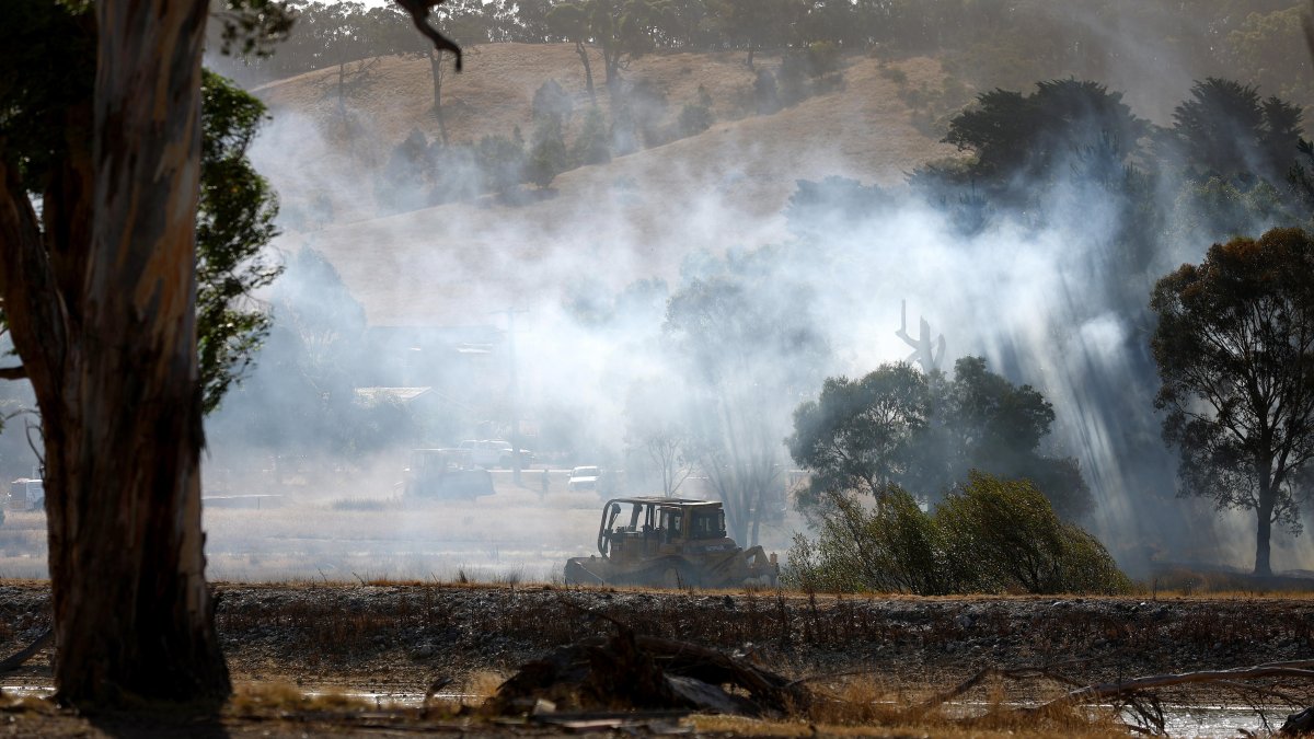 Un vehículo se encuentra en un campo mientras arde un incendio en las afueras de Beaufort, Victoria, Australia, el 28 de febrero de 2024.